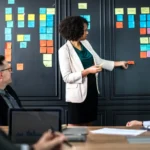 Equipe de agência reunida analisando fluxos e processos organizacionais em quadro estratégico.